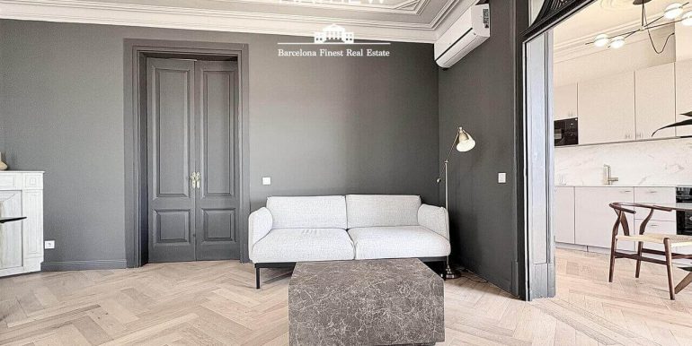 en-venta-joya-elegante-con- dos-habitaciones-frente-al-port-vell-con-rooftop-de-ensueno-y-esencia-historica-salon-3