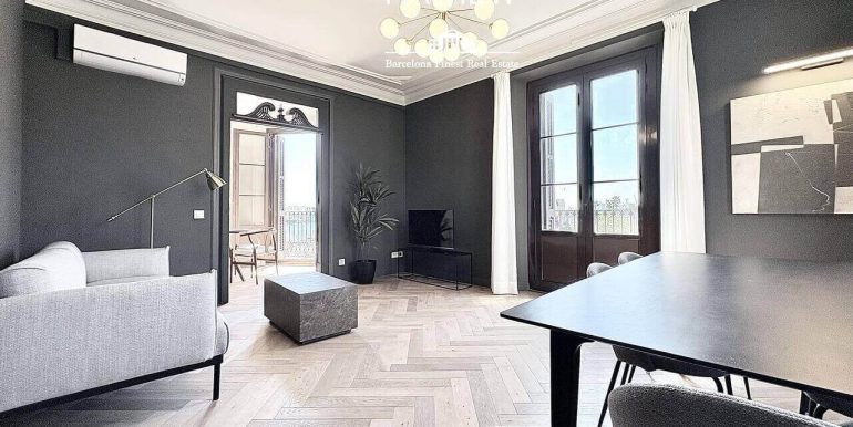 en-venta-joya-elegante-con- dos-habitaciones-frente-al-port-vell-con-rooftop-de-ensueno-y-esencia-historica-salon-7