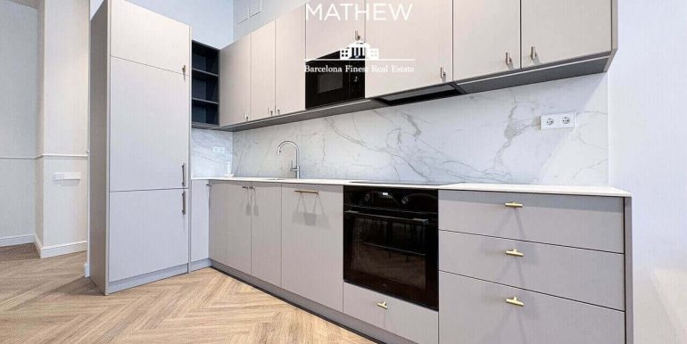 piso-exclusivo-en-venta-frente-al-port-vell-con-rooftop-piscina-y-diseno-a-estrenar-en-enclave-privilegiado-cocina-4